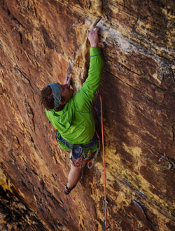 man climbing up a sheer rock face