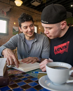 two people at a table with coffee and books
