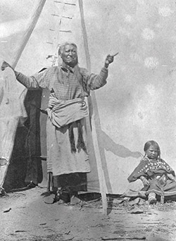 very old photo of a Native American man and young girl in front of a teepee