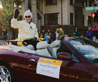 people riding in a convertible in a parade