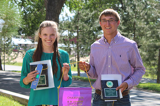 boy and girl showing ribbons, banners and trophies