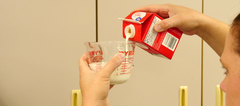 measuring cream in a liquid measuring cup