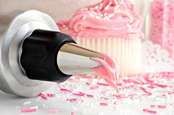 a piping bag with a pink sprinkled cupcake
