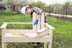 a child working on a garden bench