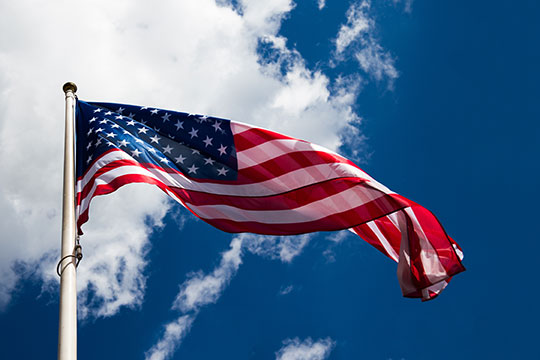 American flag in front of blue sky