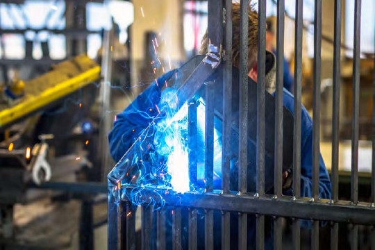 A person welding metal bars.
