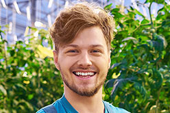 Young blonde man with a beard in overalls