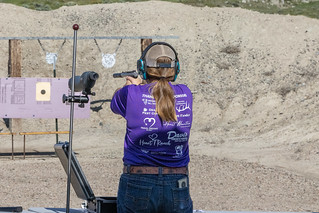 girl aiming at paper target on .22 pistol range
