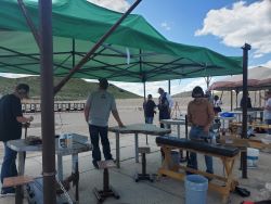 volunteers and youth under green canopy on muzzleloader range