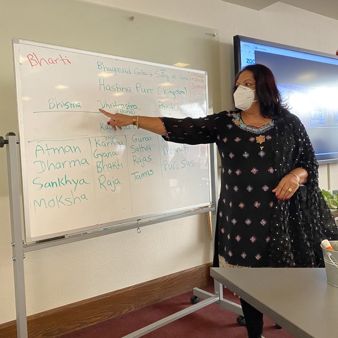 Bharti Qureshi teaching in front of a white board