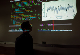 Silhouette of person examining data on a screen