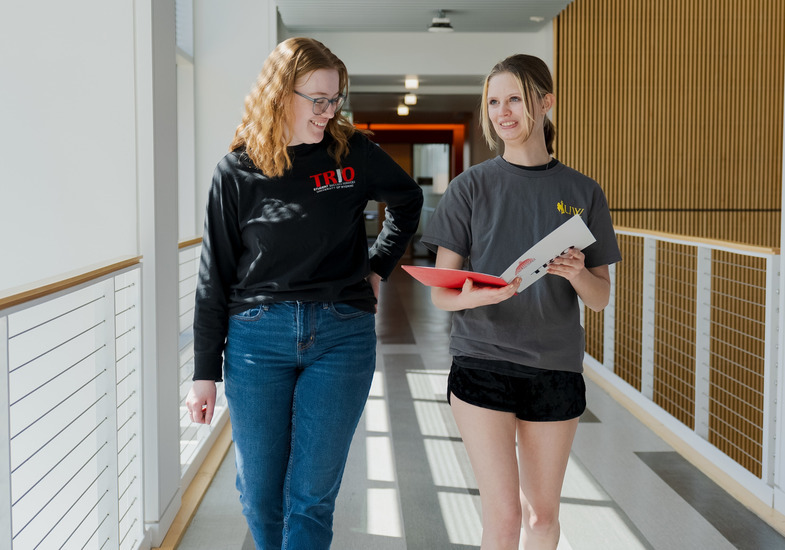 A University of Wyoming student walks with a UW advisor as they discuss academic advising services.