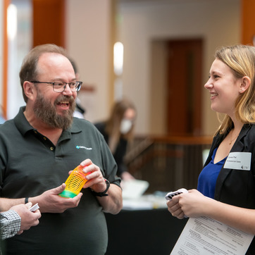 An employer speaking to a UW student at a UW career fair in the College of Business Jonah Bank Atrium