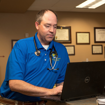 A physician from the Family Physicians of Laramie looking at his computer at the Family Physicians of Laramie facility
