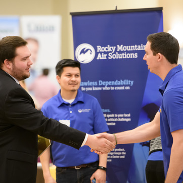 Rocky Mountain Air Solution representatives speaking to a student at a UW career fair in the Wyoming Union