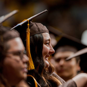 A graduate sitting at a commencement ceremony