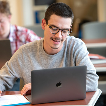 A student in the UW WWAMI program looking at a computer in the College of Health Sciences Building