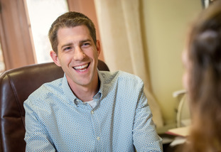 An ACES staff member smiles broadly as they provide student services to a UW undergrad.