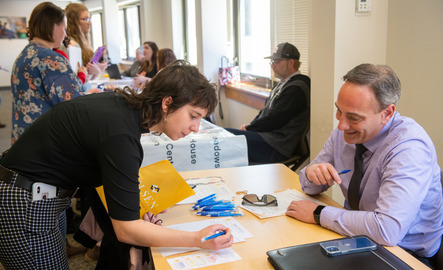 A UW student signs a paper and meets with a prospective employer at a University of Wyoming career event.