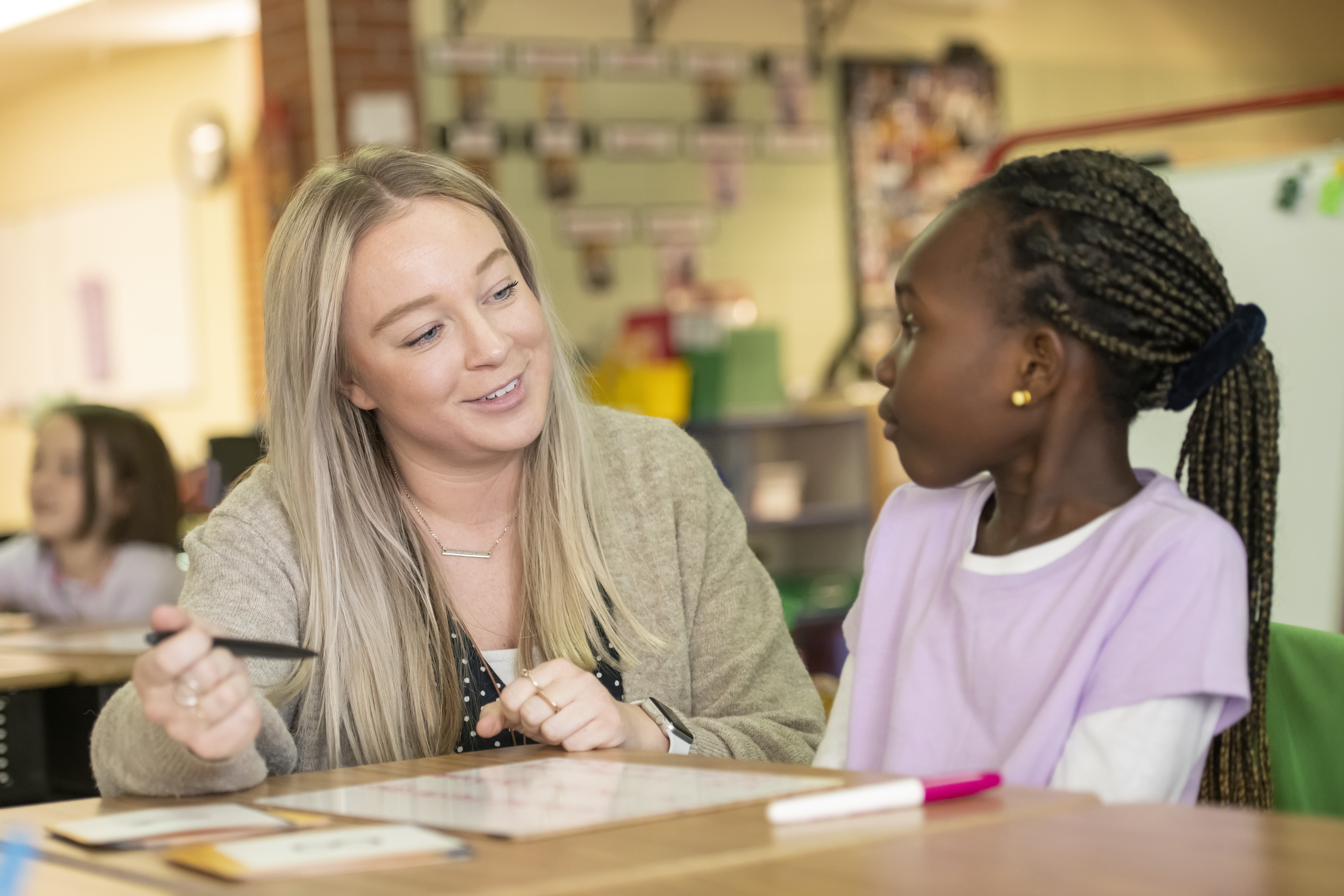 student teacher with a student in a classroom