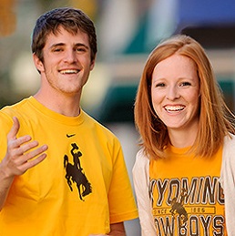 Two students in yellow shirts smile