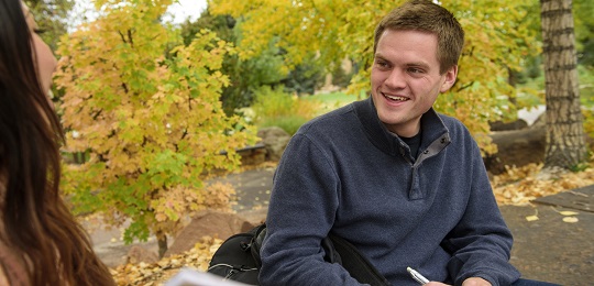 A student sits on campus in the fall.