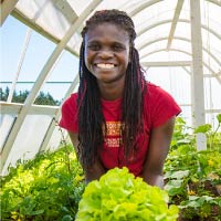 A student works in the university greenhouse for class.