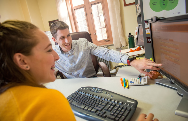 student working thier advisor at a computer screen