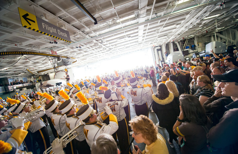 Wetern Thunder marching band lining up to go out on the football feild in front of large crowd behind the grand stands