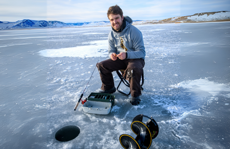 person in front of an ice fishing hole