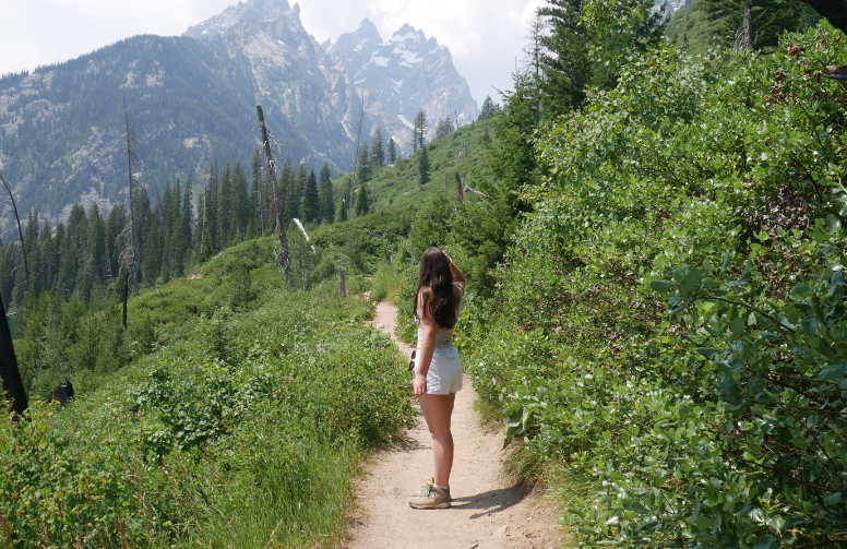 Cameron hiking on a lush green path.
