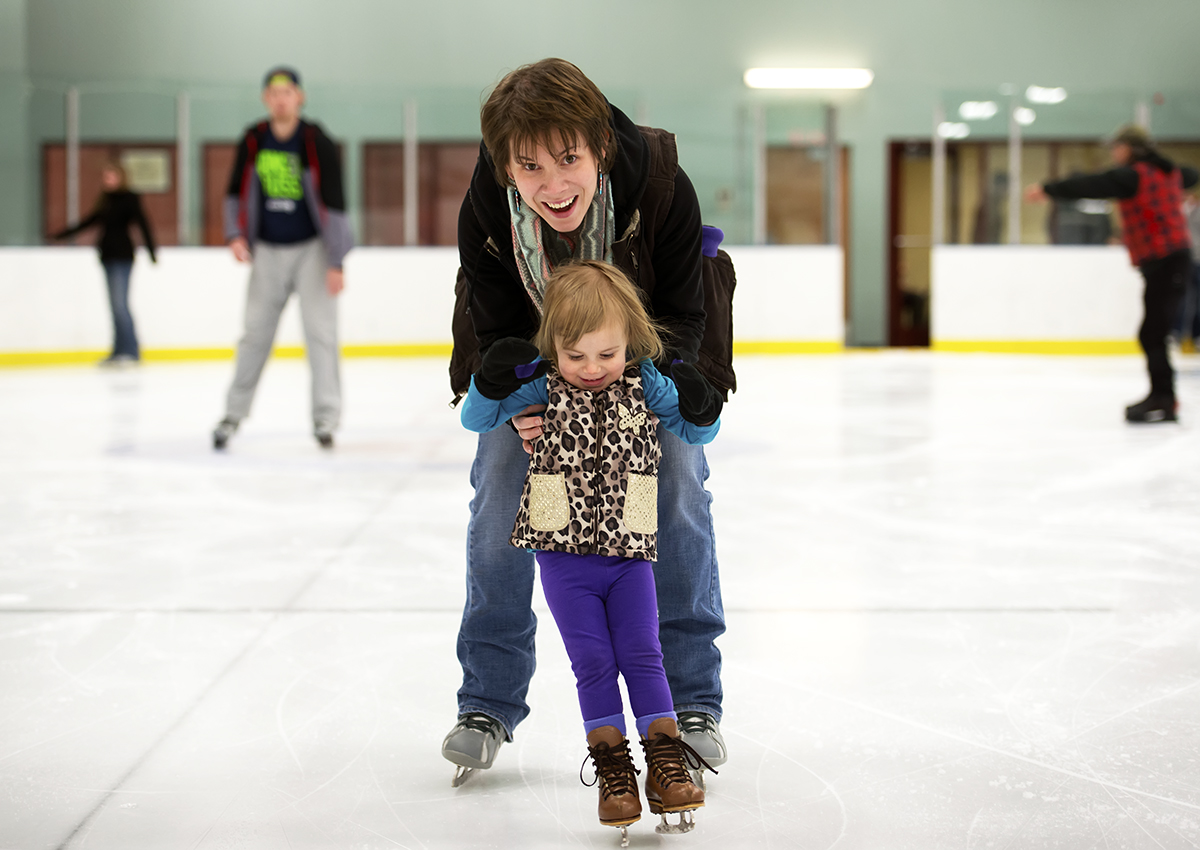 An adult and child ice skating