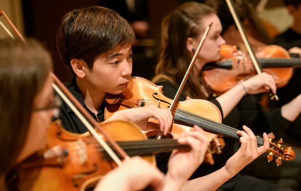 Student violin section during concert