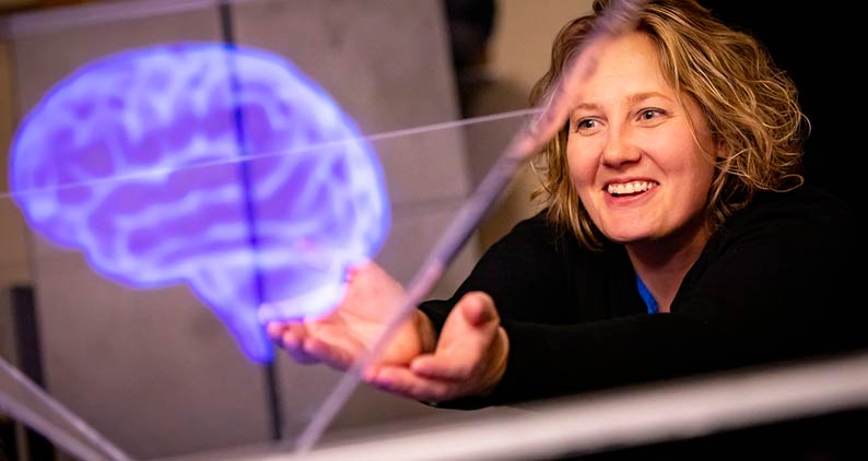 Woman interacting with holographic brain