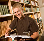 Student in the library holding open a book