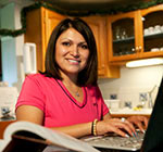 Student standing in her kitchen holding a cup of tea