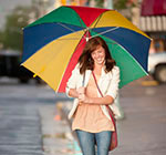 Student walking downtown in the rain