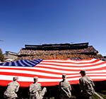 ROTC members displaying a very large Old Glory at War Memorial Stadium.