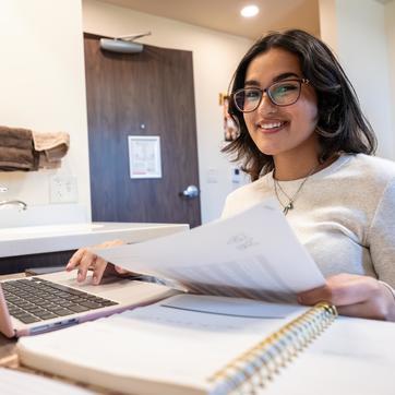 smiling student working on a laptop
