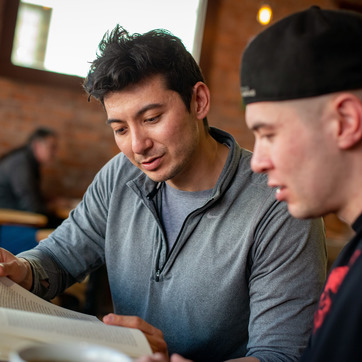 two people look over a document together