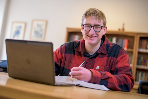 student takes notes at a computer