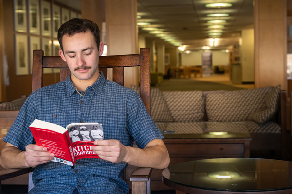 student reads a book in the library