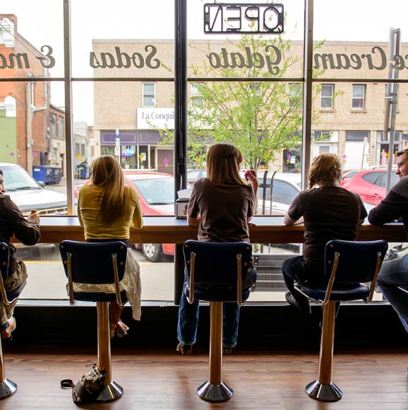 A group of student eat ice cream in a downtown shop