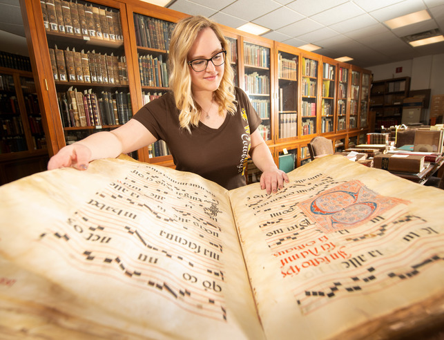 a student reviews a medieval book