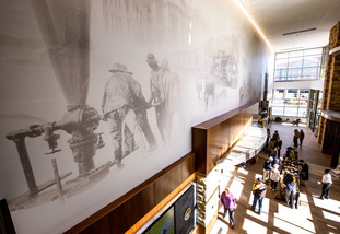A large banner at the Marian H. Rochelle Gateway Center depicts the history of natural resources in Wyoming.