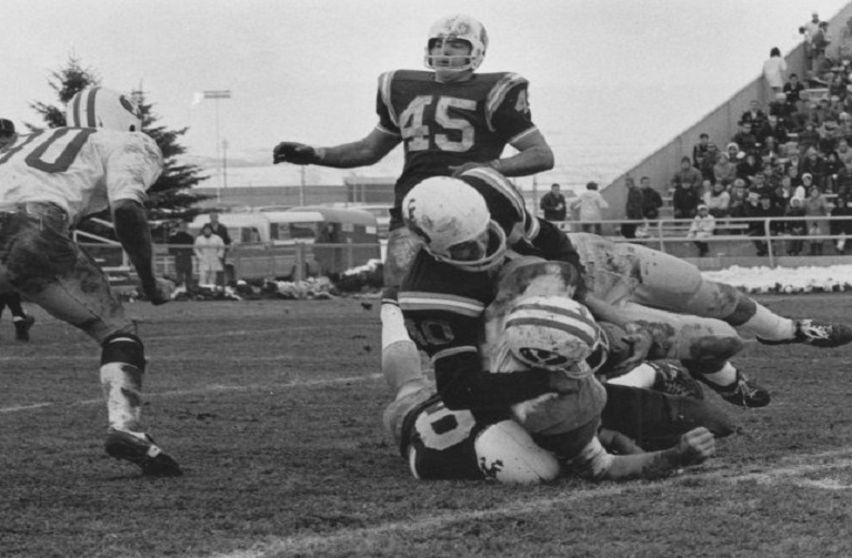 UW Football players making a takle