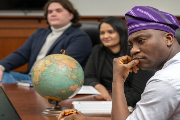 International Studies and Political Science students participate in an informal roundtable discussion. Ryan Williamson, Assistant Professor, SPPAIS (glasses, beard); Zoe Pearson, Associate Professor, SPPAIS (blonde hair, glasses); Kimika Hinoshita (Blue jacket red shirt), International Studies, Osaka, Japan; Thayne Macy (blue jacket, white shirt), Political Science, Casper, WY; Nino Gegidze (brown hair, black jacket), Political Science: Abdalrahim Abuwarda (glasses, blue button down), International Studies, Laramie, WY; Amali Sahara Bale Don (black hair, black jacket, black turtleneck), International Studies, Sri-Lanka; Blessing Ajisafe (white shirt, purple hat), Political Science, Okitipupa, Nigeria.