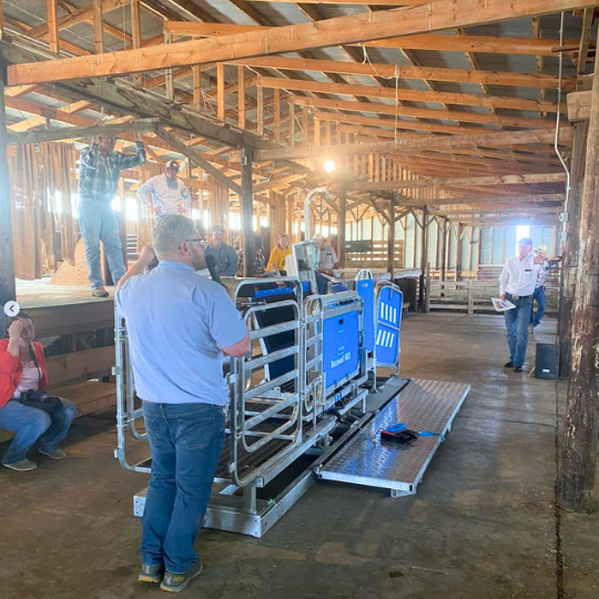 Man speaking to ranchers in barn