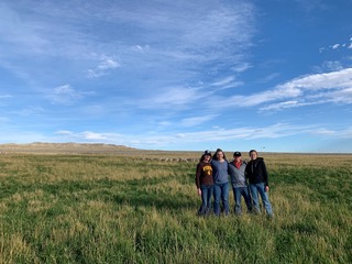 Members posing for a picture in a field