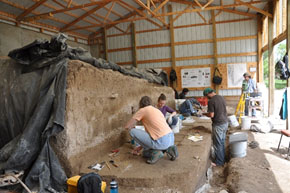 individuals work on excavations on the ground and wall at the Hell Gap National Historic Landmark